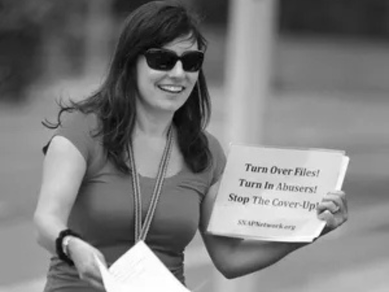 Joelle Casteix, who was sexually abused by a choir director in high school, hands out leaflets in Huntington Beach, Calif. (The Pueblo Chieftain)