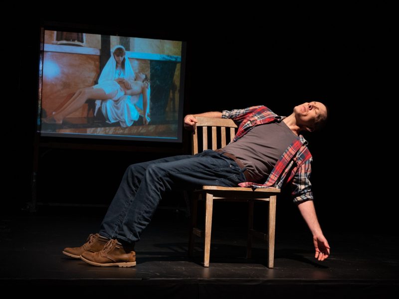 Jay Sefton Mary's Lap(1) Jay Sefton performing in his solo play "Unreconciled" against backdrop of himself as an 8th-grade Jesus in his school's passion play.
